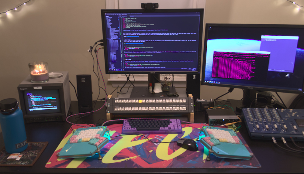 Desk with an inappropriate amount of old hardware. The two video router panels, a small studio CRT, and a four track tape recorder